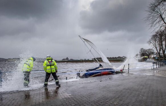 Yacht washed ashore and grounded during Storm Ciara at Cardwell Bay, Gourock, UK with H M Coastguard in attendance