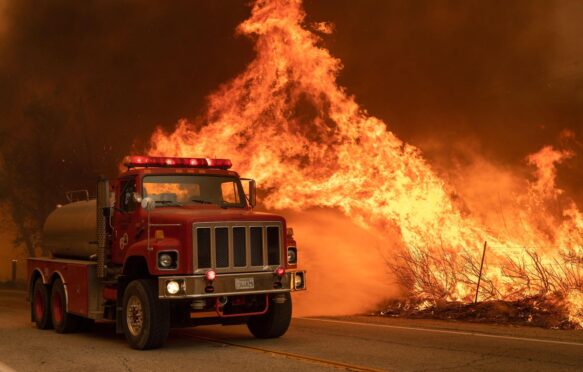 A Los Angeles County fire truck attacks flames in Valyermo, California.