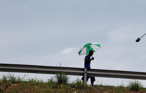 A man walking with an umbrella in hand, Lagos, Nigeria.