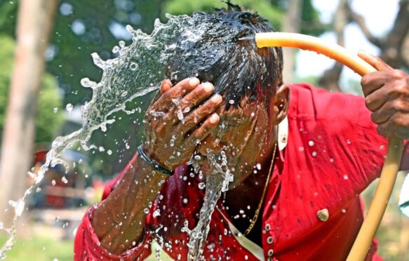 A person washes his face with water during high temperature weather day in Dhaka, Bangladesh, on April 11, 2023.