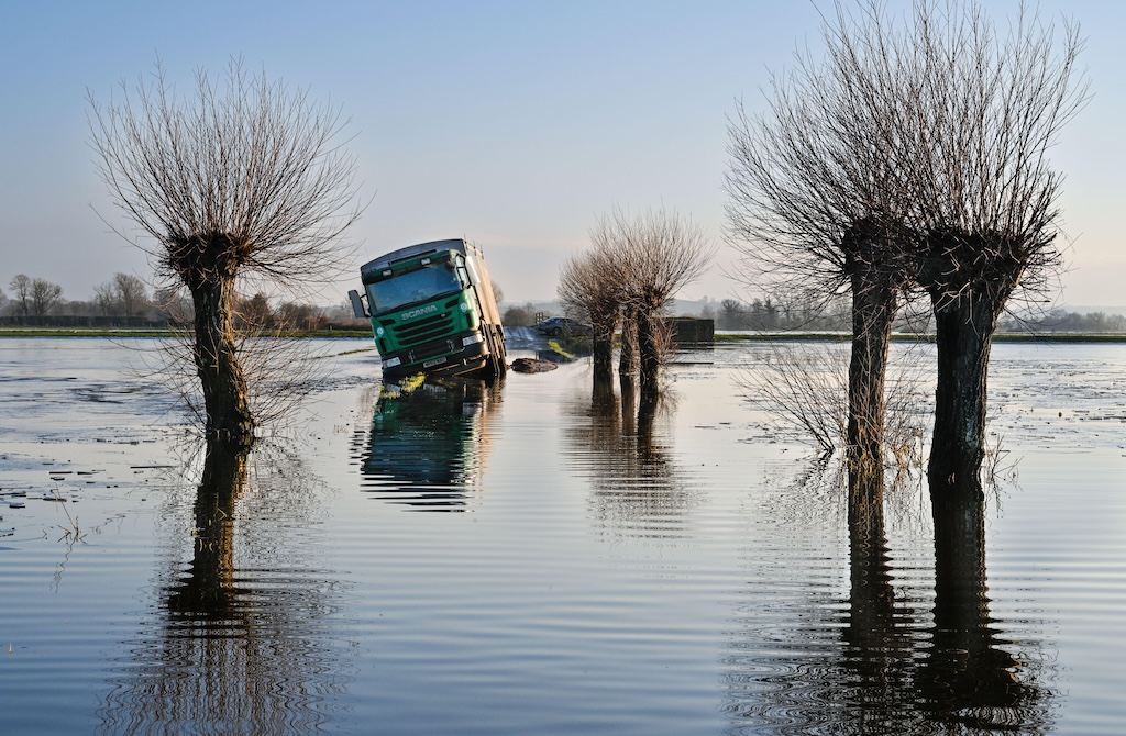 Stranded lorry driven off the road during flooding, Somerset, UK.