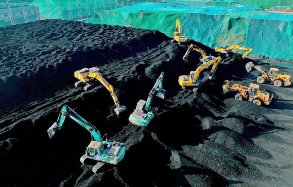 Excavators build a heap of coal in Jiangsu Province, China.