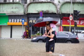 A man carrying a child wades through floodwater in Guangzhou, south China.