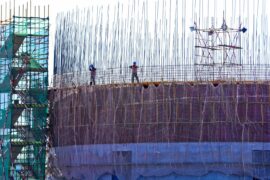 Builders bundle steel frames at a coal construction site in Gansu, China.