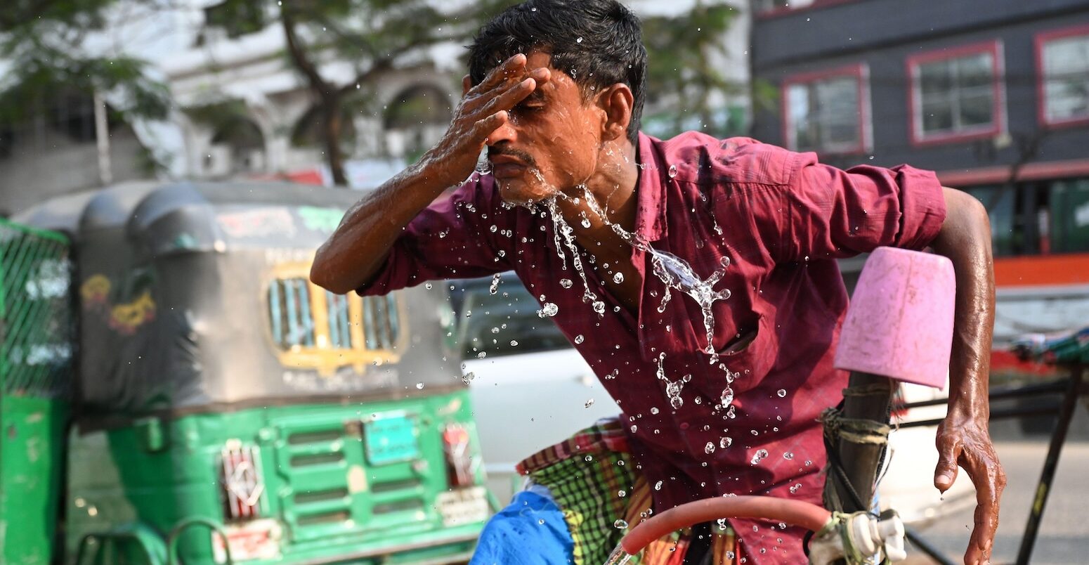 A rickshaw driver washing his face with water during a hot day in Dhaka, Bangladesh, on 15 April 2024.