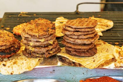 Stack of beef burgers on a grill. Credit: Alamy Stock Photo