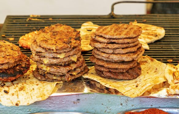 Stack of beef burgers on a grill. Credit: Alamy Stock Photo