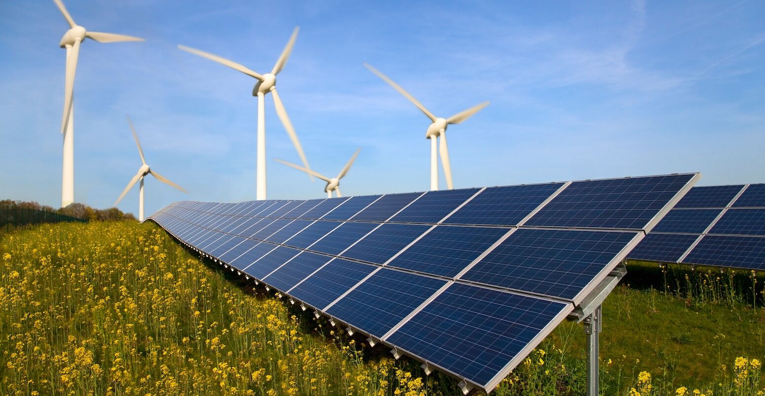 Solar panels and wind turbines in a field