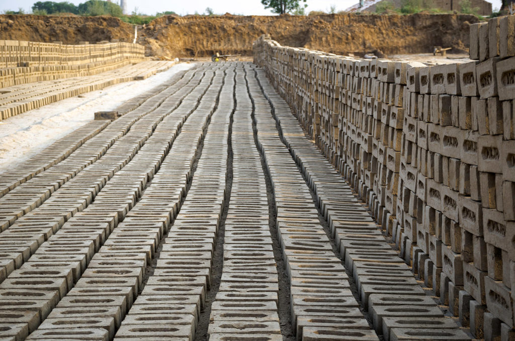 Bricks lined up to dry at a brick manufacturing facility in Amritsar, Punjab, India. Credit: GURPREET SINGH / Alamy Stock Photo. JMWXEX