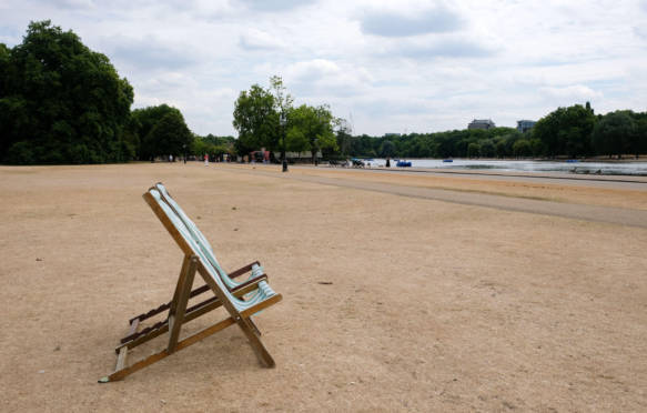 Scorched grass and empty deck chairs in Hyde Park, London, UK, during the heatwave in July 2022. Credit: Matthew Chattle / Alamy Stock Photo.