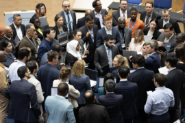 Delegates huddle during consultations on Paris Agreement Article 6.8.